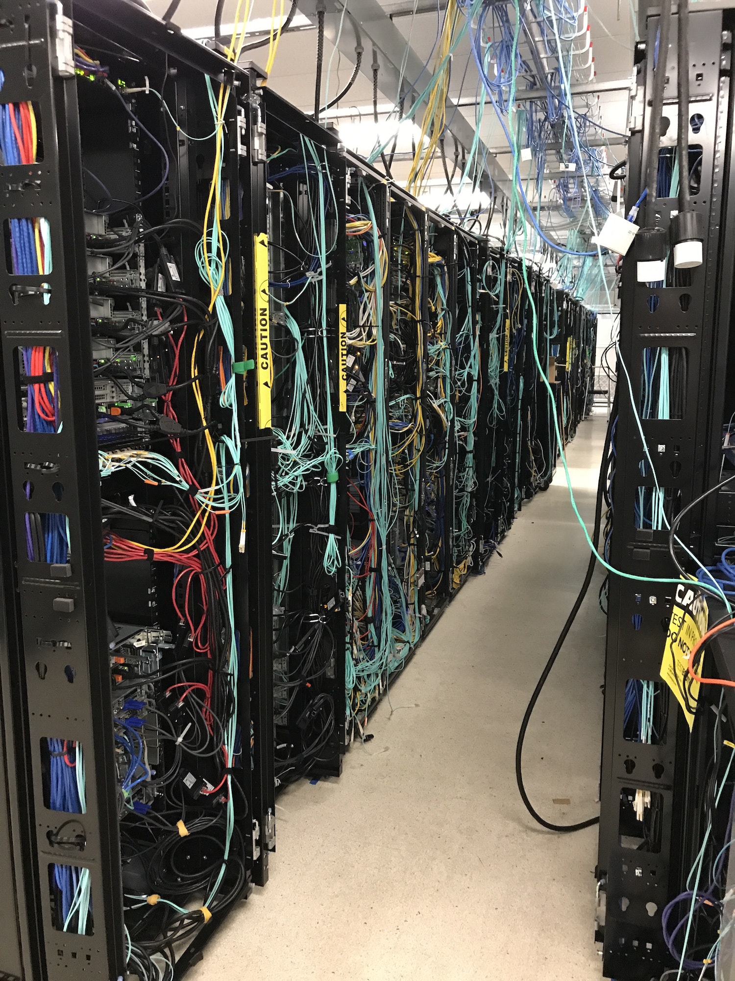 A bank of computer servers in rows and wired together at a technology internet company